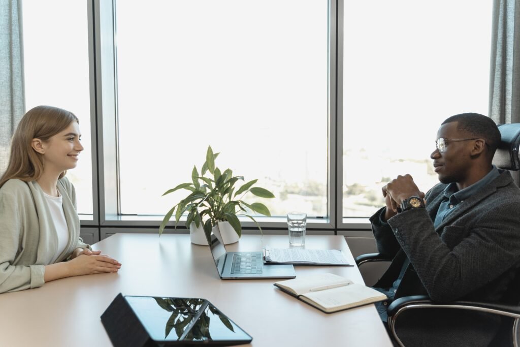 Two people sitting across a table. Man is interviewing the woman.